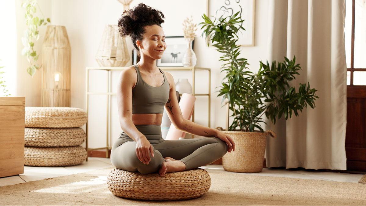 Achtsam wohnen, Frau macht Yoga in ihrer Wohnung