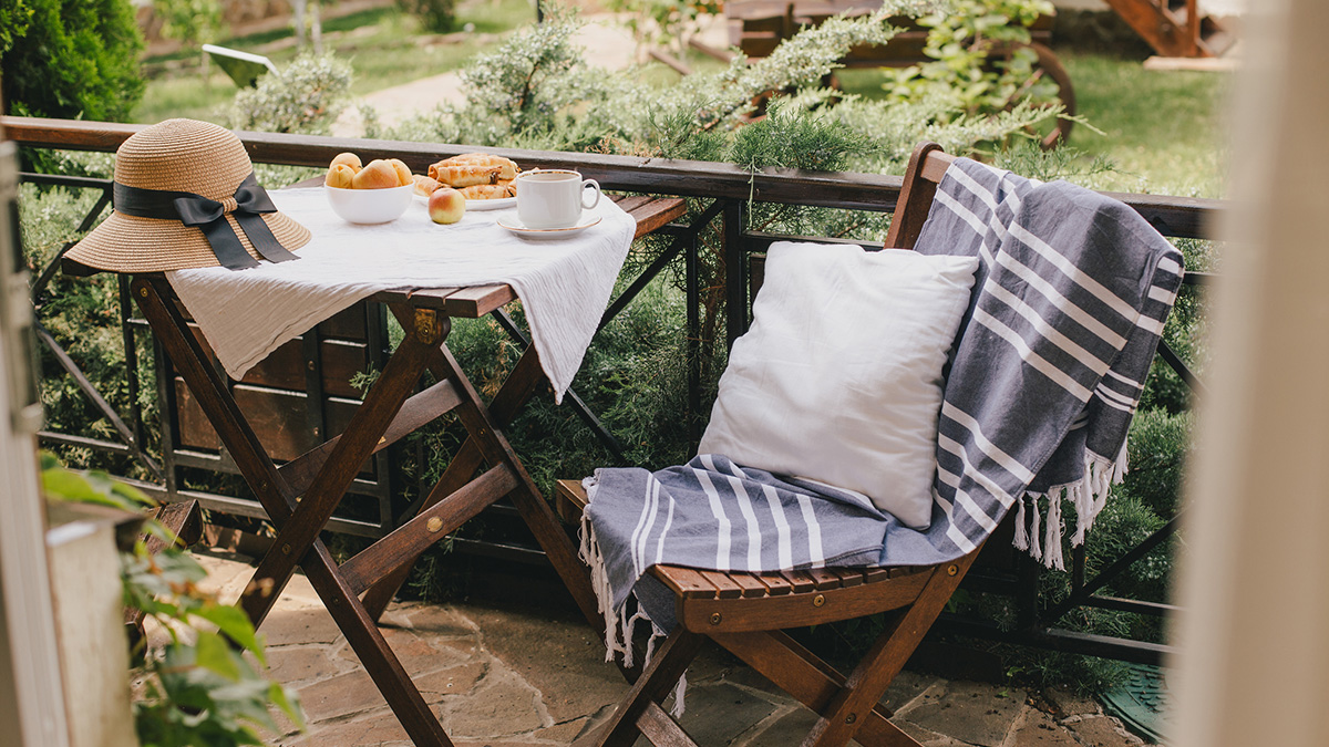 Ein Balkon mit Tisch und Stuhl von Ikea lädt zum Verweilen ein.