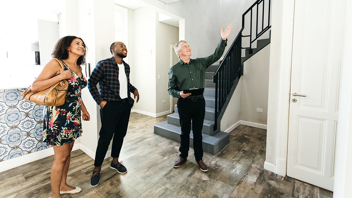 Zwangsversteigerung positiv, Makler zeigt einem Paar eine Immobilie, Foto: iStock.com / ferrantraite