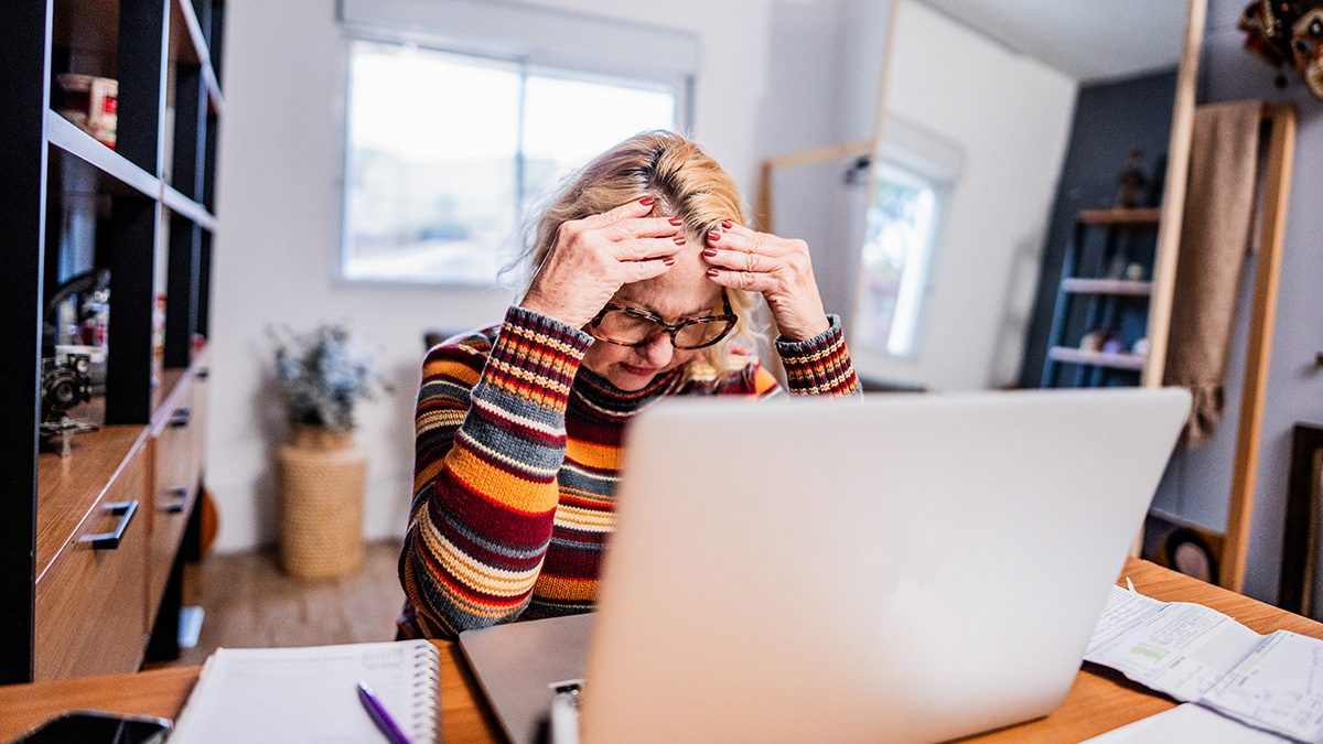Neues Heizungsgesetz Mieter, ältere Mieterin verzweifelt beim Blick auf Nebenkostenabrechnung, die nach dem neuen Heizungsgesetz gestiegen ist