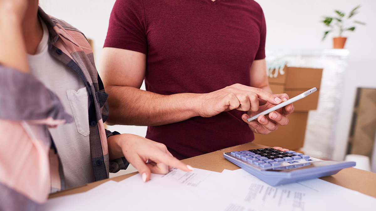 Ein Mann und eine Frau prüfen am Smartphone einen Mietvertrag