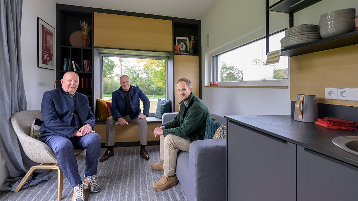 Im Wohnzimmer des Tiny-House-Mustermoduls: Oberbürgermeister Eckart Würzner (Mitte) stellt gemeinsam mit den Projektentwicklern Achim Pätzold (links) und Fabian Müller den geplanten, rückbaubaren Tiny-House-Wohnpark am Harbigweg in Kirchheim vor. Ab Sommer 2026 können dort Tiny Houses gemietet werden. (Foto: Philipp Rothe)