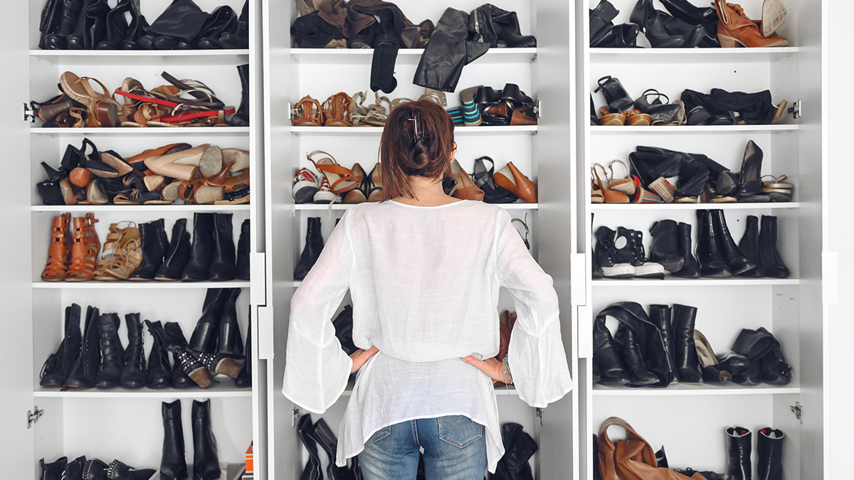 Eine Frau steht vor einem Schrank voller Schuhe