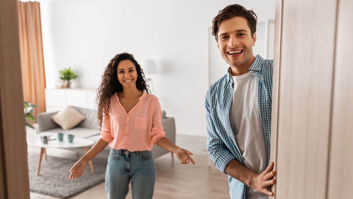 Pärchen öffnet Türe und begrüßt Freunde