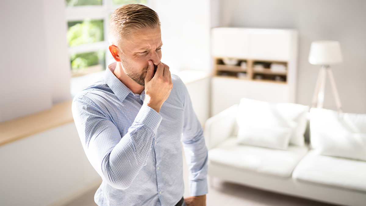 Gerüche Zuhause, Mann hält sich die Nase zu, weil es Zuhause stinkt