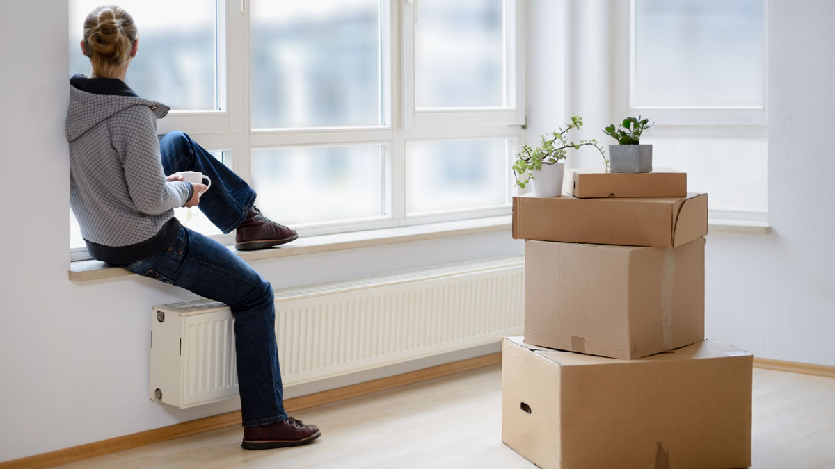 Ein junger Mensch schaut nachdenklich aus dem Fenster.