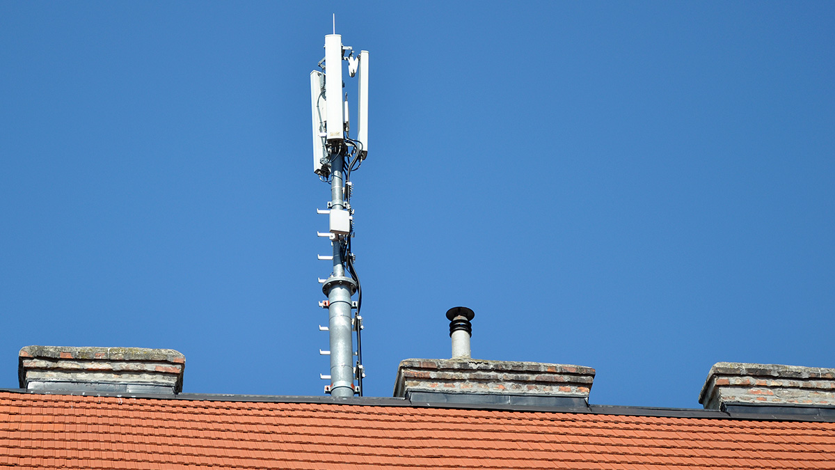 Eine Mobilfunkantenne auf einem Hausdach.