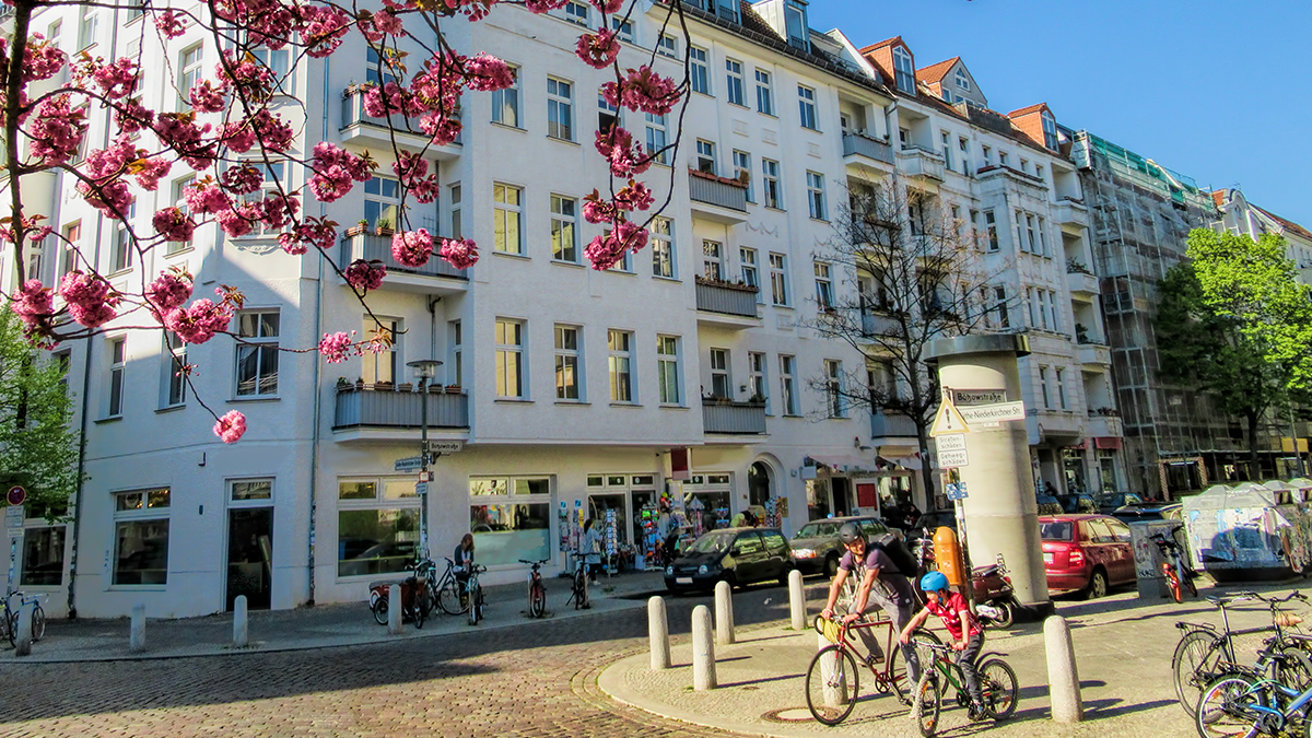 Straße in Berlin, Vater und Sohn stehen an der Ecke mit Fahrrädern