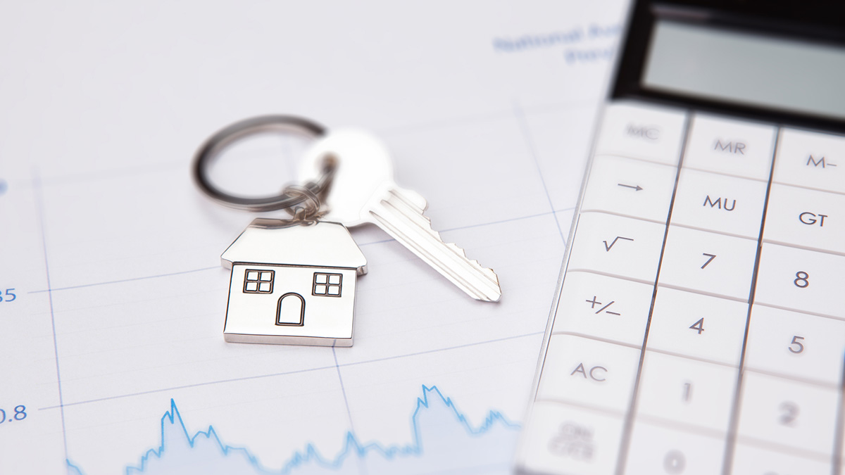 Sachwertverfahren: Ein Schlüssel mit Hausanhänger liegt neben dem Taschenrechner.