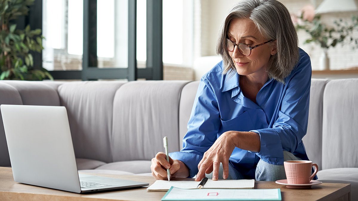 Mieterhöhung richtig formulieren, Frau macht Notizen vor ihrem Computer, Foto: insta photos / stock.adobe.com 