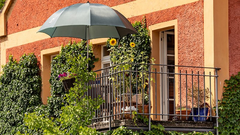 Abkühlung Balkon, Sonnenschirm und Pflanzen auf einem Balkon