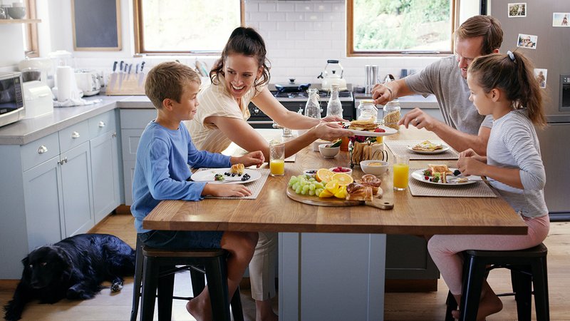 Vermietete Wohnung verkaufen, Familie sitzt in der Küche am Essenstisch, Foto: peopleimages.com / stock.adobe.com