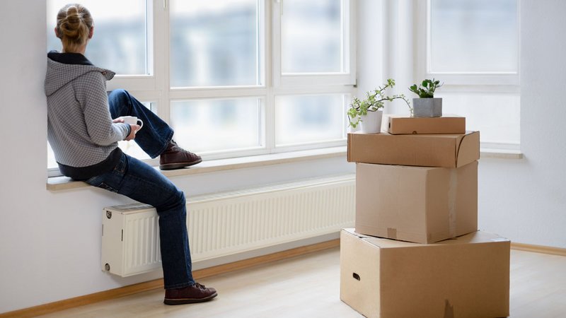 Ein junger Mensch schaut nachdenklich aus dem Fenster.