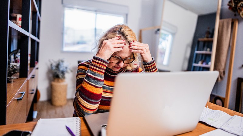 Neues Heizungsgesetz Mieter, ältere Mieterin verzweifelt beim Blick auf Nebenkostenabrechnung, die nach dem neuen Heizungsgesetz gestiegen ist