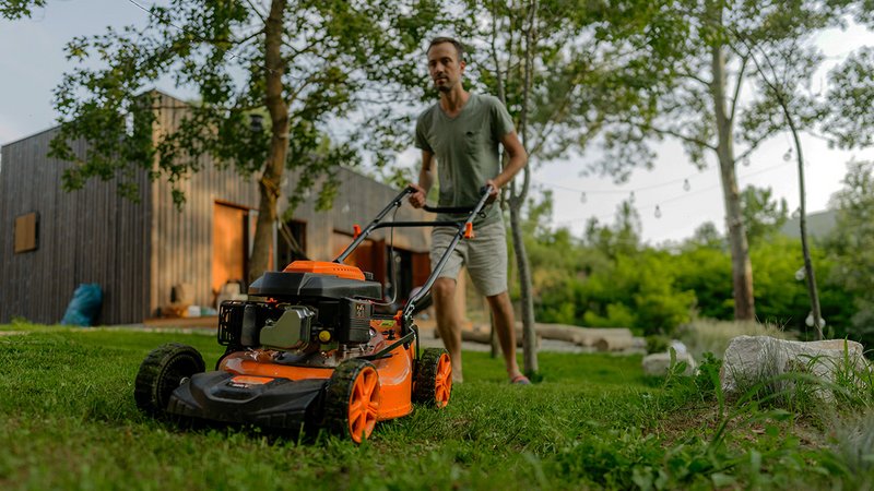 Mann beim Rasenmähen