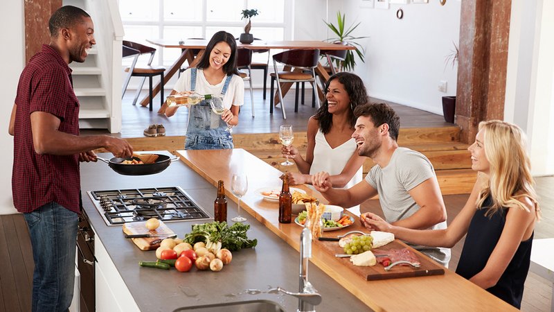 Clusterwohnungen, Menschen sitzen zusammen in einer offenen Wohnküche in ihrer Clusterwohnung