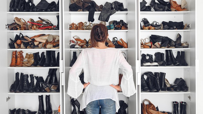 Eine Frau steht vor einem Schrank voller Schuhe