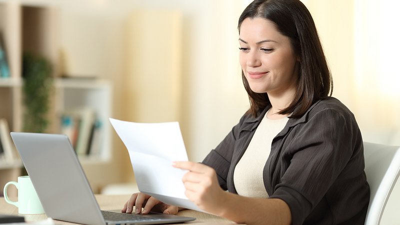 Jahresabrechnung Strom, Frau sitzt am Laptop und blickt ganz entspannt auf ihre Stromrechnung