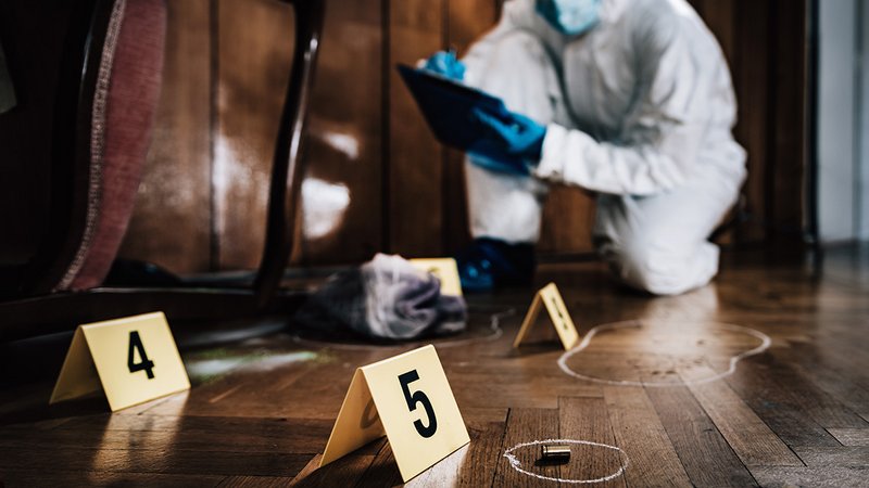 Mordhaus kaufen, ein Forensiker untersucht einen Tatort in einem Haus
