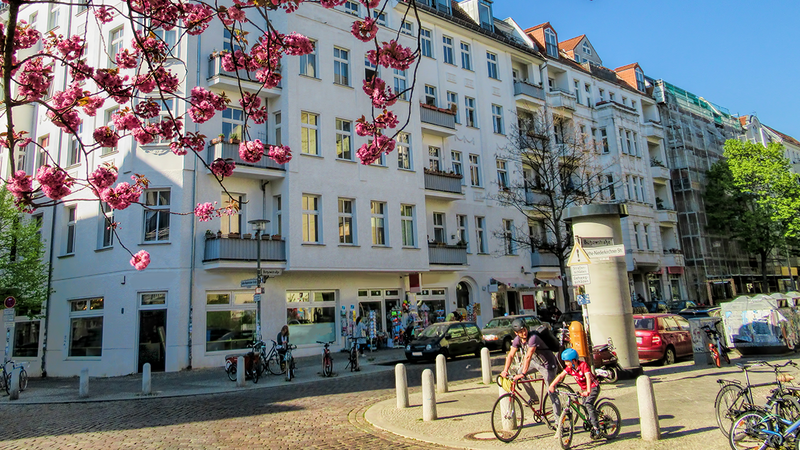 Straße in Berlin, Vater und Sohn stehen an der Ecke mit Fahrrädern