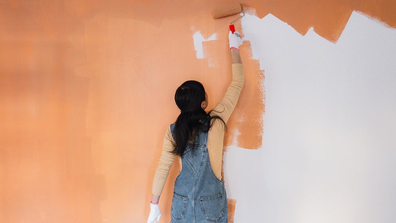 Wärmedämmfarbe, Frau bringt Wärmedämmfarbe an