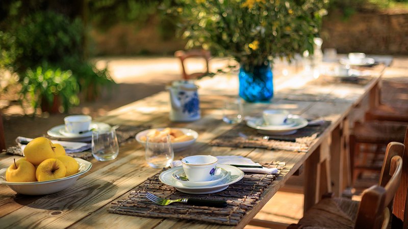 Taormina-Stil: Ein langer gedeckter Holztisch im Freien.