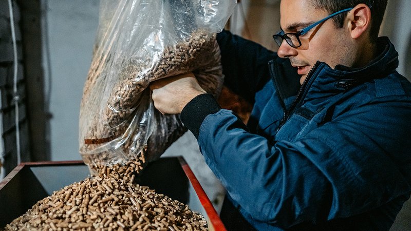 Pelletofen Lärm, Mann füllt Pellets nach