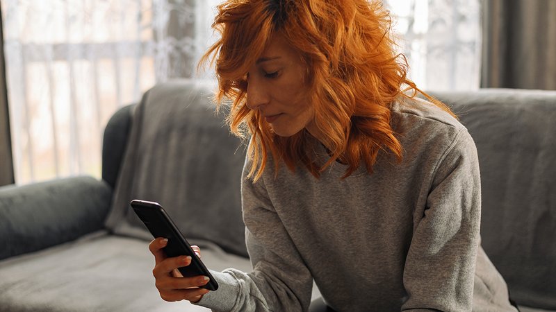 Frau sucht Wohnungen auf dem Smartphone. Foto: iStock.com / Zamrznuti tonovi 