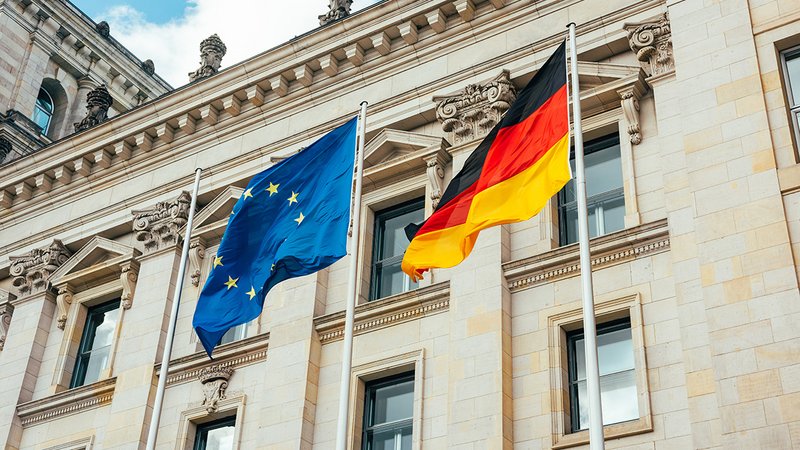 Neues Heizungsgesetz versus EU-Recht, EU- und Deutschland-Flagge vor dem deutschen Reichstag