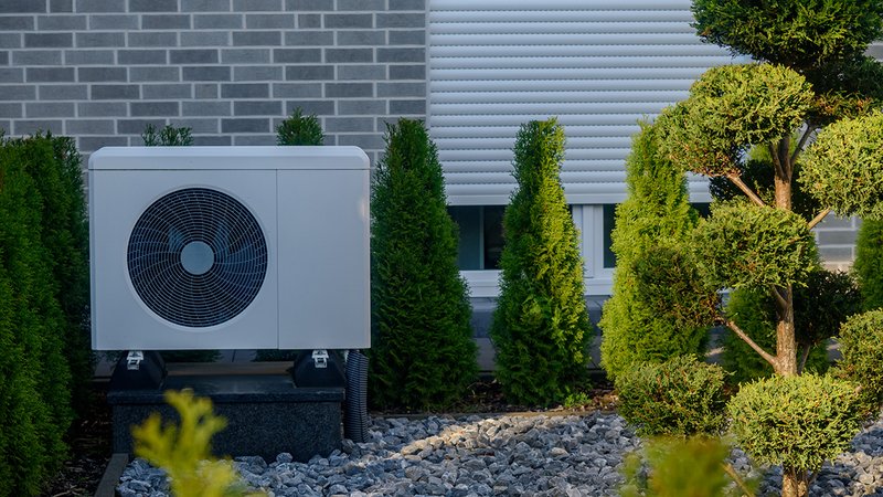 Eine Wärmepumpe im Garten eines Hauses