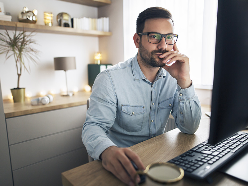 Homeoffice steuerlich absetzen, Mann sitzt vor einem PC in einem Arbeitszimmer