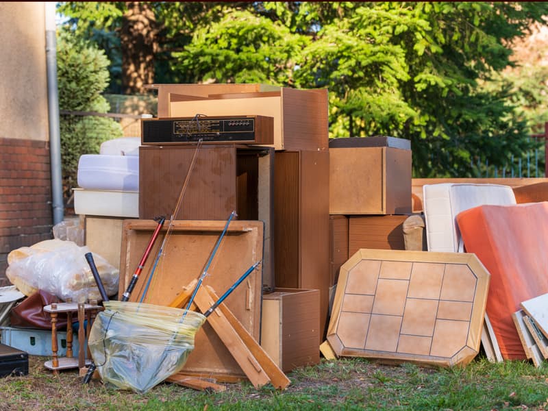 Haushaltsauflösung, Sperrmüll steht in einem Garten,