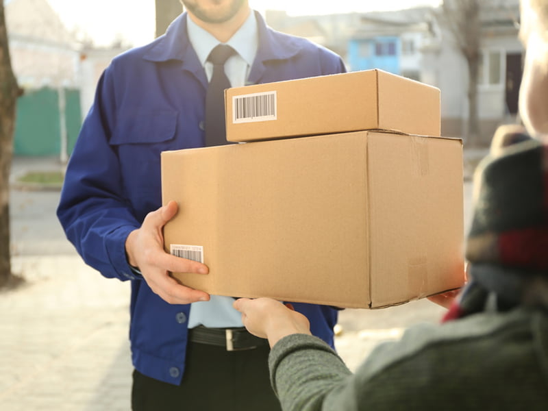 Nachsendeauftrag, Paket, Postbote, Übergabe, Mann übergibt zwei Pakete an Person.