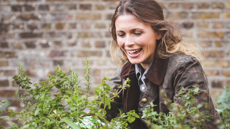 Eine Frau beim Einpflanzen im Garten.
