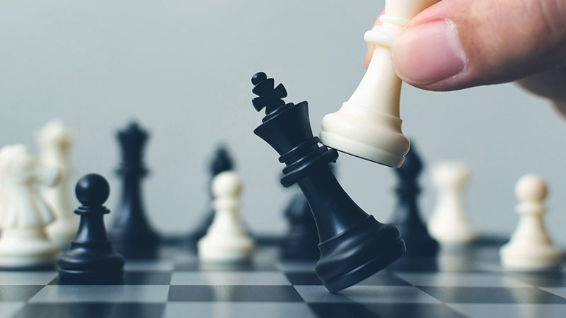 Auf einem Schachbrett schlägt der weiße den schwarzen König