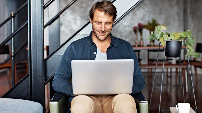 Mängelanzeige, Mann sitzt mit Laptop auf seinem Schoß in einem Sessel, 