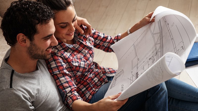 Ein Mann und eine Frau schauen sich einen Grundriss an