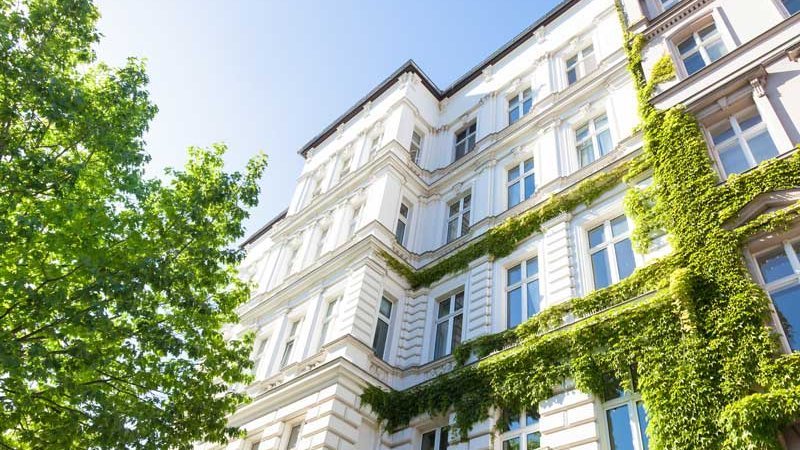 mieten oder kaufen, Bild eines Mehrfamilienhauses im Sonnenschein